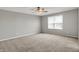 A bright bedroom with carpet, a ceiling fan, and a large window providing plenty of light at 12951 Corydon Dr, Fishers, IN 46037