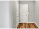 Hallway with neutral paint and hardwood floors leading to doors, offering ample storage and space at 12951 Corydon Dr, Fishers, IN 46037