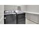 A laundry room with a modern washer and dryer, shelving, and neutral walls, offering convenience and functionality at 12951 Corydon Dr, Fishers, IN 46037