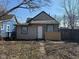 Overgrown backyard with trees and detached garage with adjacent building structures and sidewalks at 1342 W Lee St, Indianapolis, IN 46221