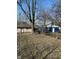Overgrown backyard with large trees, detached garages and storage with adjacent building structures at 1342 W Lee St, Indianapolis, IN 46221