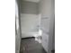 Bathroom with a white bathtub, toilet, sink and cabinets, plus a vinyl floor at 1342 W Lee St, Indianapolis, IN 46221