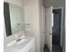 Bathroom with white sink and cabinets, a mirror, and doorway view into a bedroom at 1342 W Lee St, Indianapolis, IN 46221