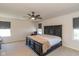 Spacious bedroom with a dark wood bed frame, ceiling fan, and natural light from two windows at 1370 Timber Bluff Rd, Westfield, IN 46074