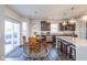 Bright dining area features sliding doors, a modern light fixture, and an adjacent island and kitchen area at 1370 Timber Bluff Rd, Westfield, IN 46074