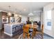 Open-concept living area with bar seating, dining table, and staircase leading to upper floors at 1370 Timber Bluff Rd, Westfield, IN 46074