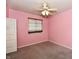 Empty pink bedroom with a window, closet, and neutral carpeting at 1472 Maria Ave, Franklin, IN 46131