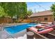 Outdoor pool with sun loungers, mature trees, and a brick pool house creates a serene backyard escape at 1510 Central Ave, Indianapolis, IN 46202