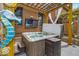 Relaxing hot tub area with mounted television, surrounded by a brick wall and pergola, ideal for outdoor entertainment at 1510 Central Ave, Indianapolis, IN 46202