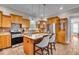 Well-lit kitchen with stainless steel appliances, wooden cabinets, a tile backsplash, an island with barstools, and tile floors at 1510 Central Ave, Indianapolis, IN 46202
