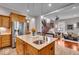 Open kitchen with an island, stainless steel appliances, wood cabinets, connecting to a living room and a wooden staircase at 1510 Central Ave, Indianapolis, IN 46202