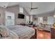 Spacious main bedroom with hardwood floors, ceiling fan, sitting area, desk and bed, and large windows for natural light at 1510 Central Ave, Indianapolis, IN 46202