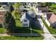 Aerial view showcasing the home's position and curb appeal, framed by mature trees and a green lawn at 1615 N E St, Elwood, IN 46036