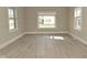 Bright living room features new flooring, fresh paint, and ample natural light streaming through large windows at 1615 N E St, Elwood, IN 46036