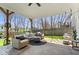 Relaxing covered patio with comfortable seating around a fire pit and a view of the backyard at 16726 Blackbird Ct, Noblesville, IN 46060
