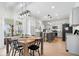 View of a dining area and kitchen with a wooden dining table, seating for six, and modern lighting fixtures at 16726 Blackbird Ct, Noblesville, IN 46060