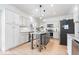 Modern kitchen with white cabinets, stainless steel appliances, and a stylish island with seating at 16726 Blackbird Ct, Noblesville, IN 46060