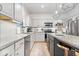 Bright kitchen features white cabinets, granite countertops, stainless steel appliances, and a stylish island with seating at 16726 Blackbird Ct, Noblesville, IN 46060