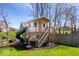 Fun backyard playhouse with slide and stairs, surrounded by a wooden fence at 16726 Blackbird Ct, Noblesville, IN 46060