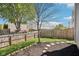 View of a backyard with a wood fence, grass and a small garden area in front of the house at 16780 Lowell Dr, Noblesville, IN 46060