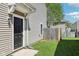 Side view of the home exterior with a black front door, siding, and lawn at 16780 Lowell Dr, Noblesville, IN 46060
