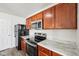Kitchen featuring black appliances, wood cabinets, and marble countertops at 16780 Lowell Dr, Noblesville, IN 46060