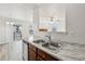 Open concept kitchen with a stainless steel sink, wood cabinets, and a view to the living room at 16780 Lowell Dr, Noblesville, IN 46060