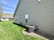 Exterior side view of the home with green lawn and central air conditioning unit at 16869 Cimarron Pass, Noblesville, IN 46060