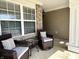 Relaxing front porch featuring comfortable wicker seating, a small table, and a view of the neighborhood at 16869 Cimarron Pass, Noblesville, IN 46060
