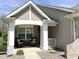 Inviting front porch with brick support columns, comfortable seating, and attractive landscaping at 16869 Cimarron Pass, Noblesville, IN 46060