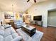 Open living area featuring vaulted ceiling, wood floors, and comfortable gray seating at 16869 Cimarron Pass, Noblesville, IN 46060