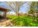Landscaped backyard featuring a large tree, trimmed grass, and a wood fence at 1908 Roundhill Dr, Anderson, IN 46013