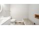 Bathroom features white vanity, matching toilet, and neutral-toned flooring with a bench at 1908 Roundhill Dr, Anderson, IN 46013