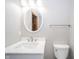 Well-lit bathroom features white vanity, oval mirror, and modern faucet fixtures at 1908 Roundhill Dr, Anderson, IN 46013