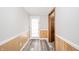 Hallway features gray flooring, natural wood wainscoting, and a frosted glass exterior door at 1908 Roundhill Dr, Anderson, IN 46013