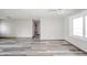 Bright living room featuring gray wood flooring and neutral walls with a hallway view at 1908 Roundhill Dr, Anderson, IN 46013