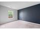 Minimalist bedroom featuring a large window and a dark accent wall at 19516 Golden Meadow Way, Noblesville, IN 46060