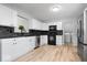 Modern kitchen with white cabinets, black countertops, and stainless steel appliances at 19516 Golden Meadow Way, Noblesville, IN 46060