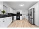 Modern kitchen with white cabinetry, stainless steel appliances, and contrasting black backsplash at 19516 Golden Meadow Way, Noblesville, IN 46060