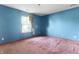 A bright bedroom with blue walls, a window letting in natural light and a pink carpet at 2102 Coldwater Cir, Indianapolis, IN 46239