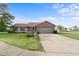 Charming one-story home featuring brick accents, attached garage and a lush green lawn at 2102 Coldwater Cir, Indianapolis, IN 46239