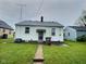 Back exterior of a single-story home featuring a grassy yard and a paved walkway at 2309 Pennsylvania St, Columbus, IN 47201