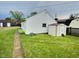 View of backyard with white vinyl siding, well-maintained lawn and a pathway leading away from the house at 2309 Pennsylvania St, Columbus, IN 47201