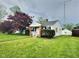 View of a charming home with green lawn and red tree at 2309 Pennsylvania St, Columbus, IN 47201