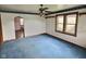 View of a living room with hardwood trim, carpet, a ceiling fan, and natural light at 2309 Pennsylvania St, Columbus, IN 47201