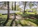 Backyard features a fire pit area and a view of the white fence and neighboring houses, all surrounded by beautiful trees at 233 N Fenton Ave, Indianapolis, IN 46219