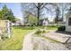 Spacious backyard with beautiful green grass, landscaping, and a pathway to a shed at 233 N Fenton Ave, Indianapolis, IN 46219
