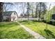 Large backyard with green grass and a walking path leading to the outbuilding and privacy fence at 233 N Fenton Ave, Indianapolis, IN 46219