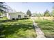 This home offers a beautiful backyard, complete with a pathway through lush green grass and landscaping at 233 N Fenton Ave, Indianapolis, IN 46219