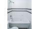 Bathroom features a tiled tub with shower and sleek design at 233 N Fenton Ave, Indianapolis, IN 46219